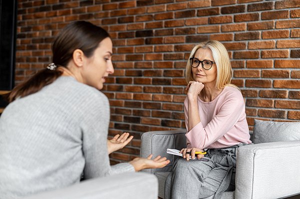 Worried Young Woman Patient Sitting At A Psychologists Therapist listening