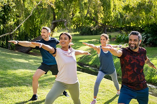 Mature multiethnic couple doing sport and physical exercises out group exercise